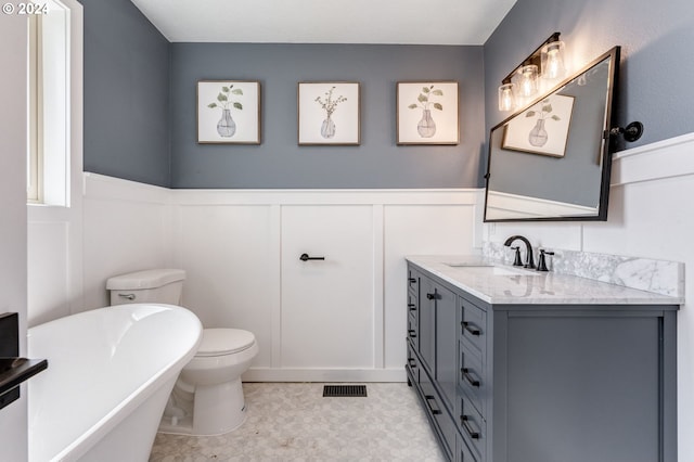 bathroom with toilet, a tub, and vanity