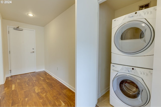 clothes washing area with light hardwood / wood-style flooring and stacked washing maching and dryer