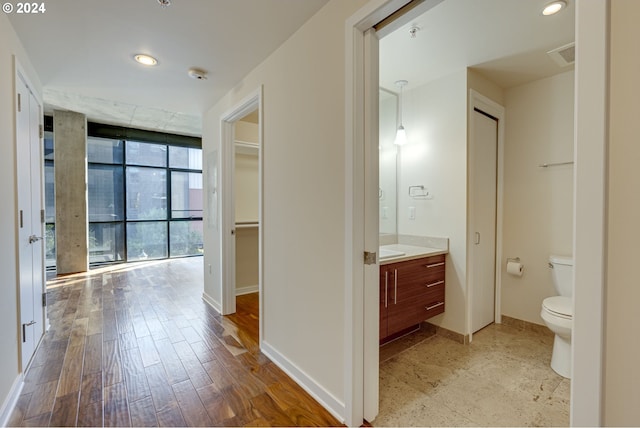 hall with light wood-type flooring and floor to ceiling windows