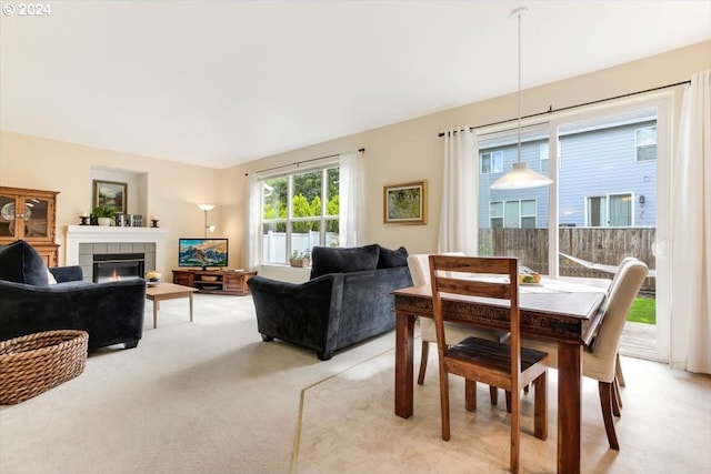 dining space featuring light colored carpet and a fireplace