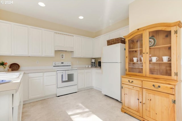 kitchen featuring white appliances, white cabinetry, and sink