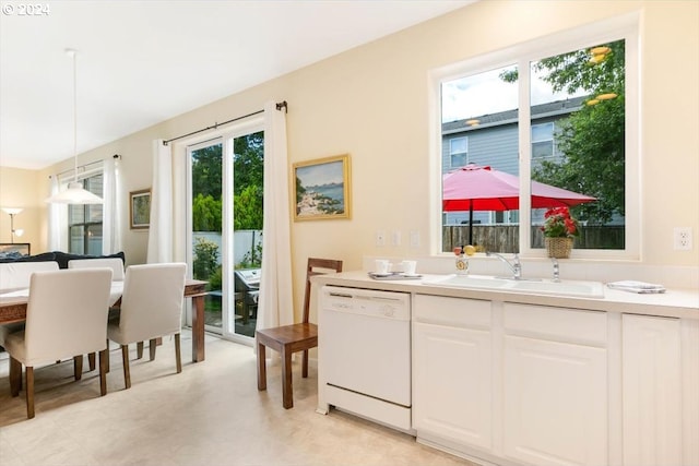 kitchen featuring white dishwasher, hanging light fixtures, sink, and white cabinetry