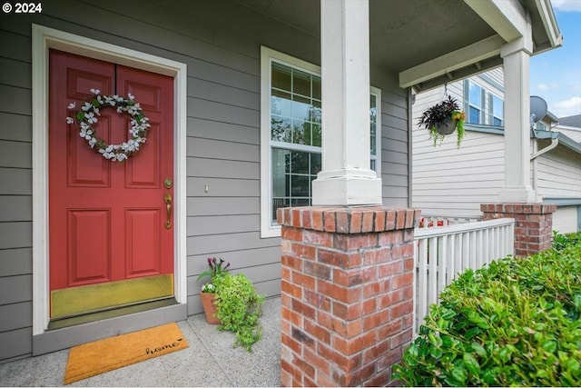 view of exterior entry featuring covered porch