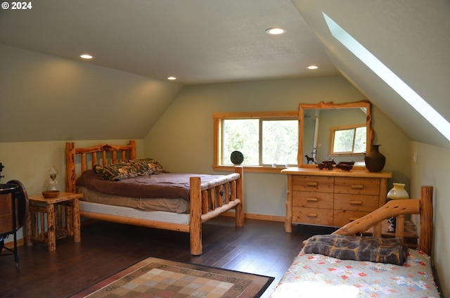 bedroom with dark hardwood / wood-style floors and lofted ceiling with skylight