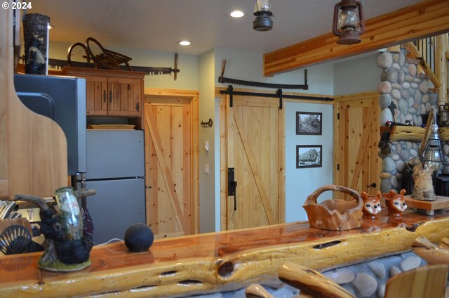 kitchen with a barn door, a textured ceiling, and white fridge