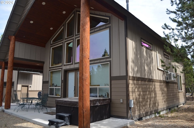 view of side of home featuring a patio and a hot tub