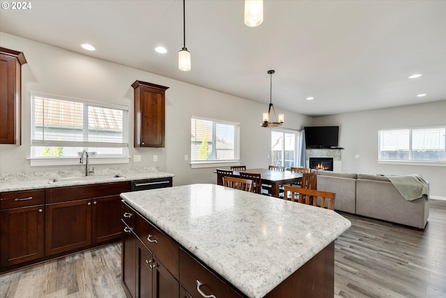 kitchen with hardwood / wood-style flooring, a center island, sink, and pendant lighting