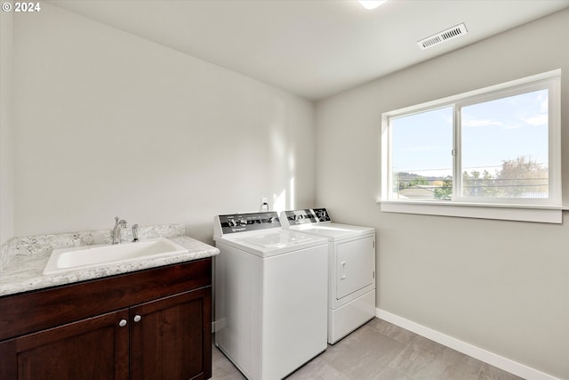 laundry room with cabinets, separate washer and dryer, and sink