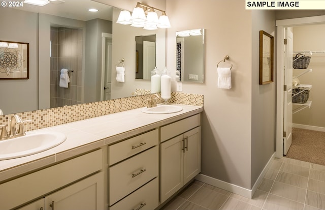 bathroom with tile patterned floors, backsplash, vanity, and a chandelier