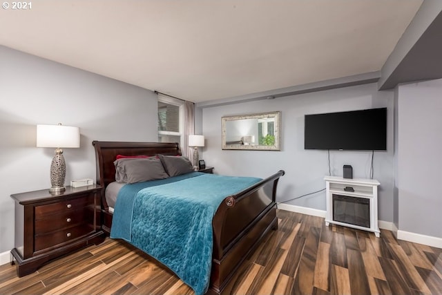 bedroom with dark hardwood / wood-style flooring