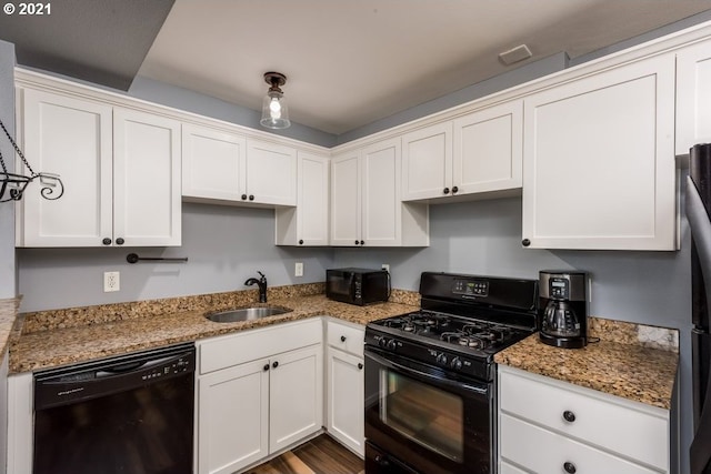 kitchen with black appliances, sink, stone countertops, white cabinetry, and hardwood / wood-style flooring