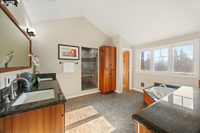 kitchen featuring sink, vaulted ceiling, and dark stone counters