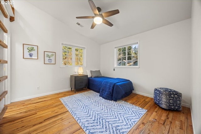 bedroom featuring multiple windows, vaulted ceiling, light hardwood / wood-style floors, and ceiling fan