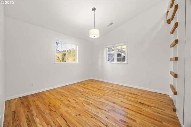 spare room with light hardwood / wood-style flooring and vaulted ceiling