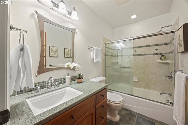 full bathroom featuring enclosed tub / shower combo, vanity, and toilet