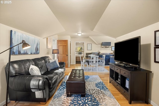 living room with vaulted ceiling and light hardwood / wood-style flooring