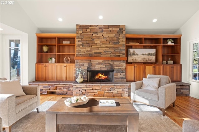 living room featuring a stone fireplace and light hardwood / wood-style flooring