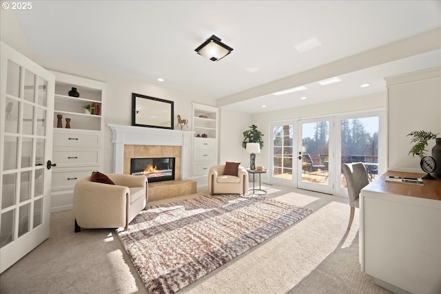 living room with light carpet, built in shelves, a fireplace, and french doors