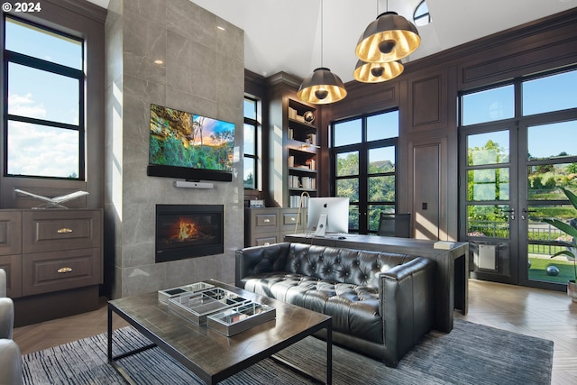 living room featuring parquet floors, a tiled fireplace, and plenty of natural light