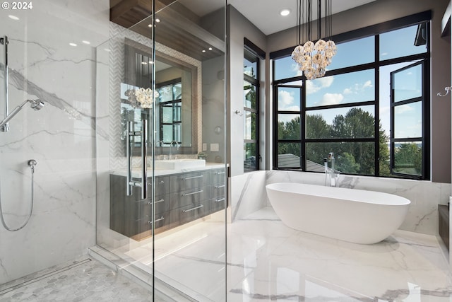 bathroom with tile walls, vanity, separate shower and tub, and a chandelier