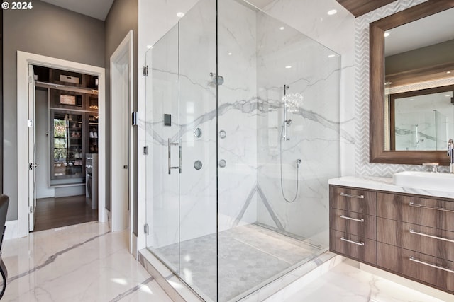 bathroom featuring a shower with door and vanity