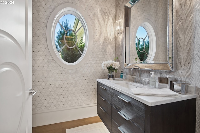 bathroom with vanity, tile walls, hardwood / wood-style flooring, and a healthy amount of sunlight