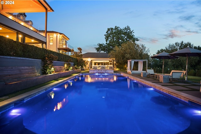 pool at dusk featuring a patio