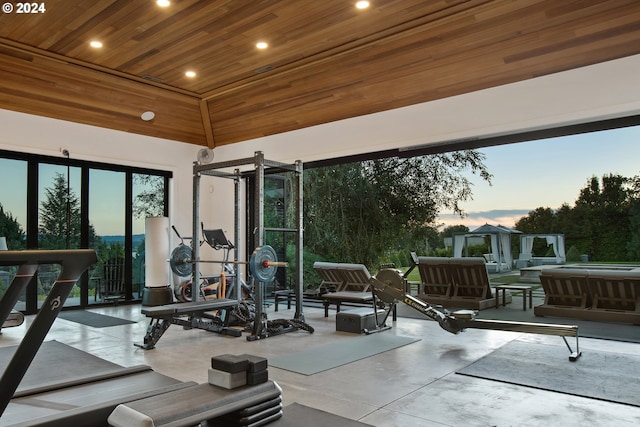 interior space with concrete flooring, wood ceiling, and a high ceiling