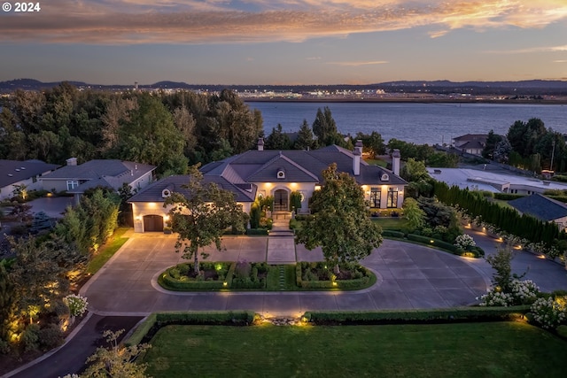 aerial view at dusk featuring a water view