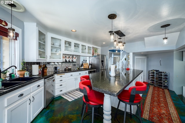 kitchen featuring backsplash, stainless steel appliances, a center island, sink, and white cabinets