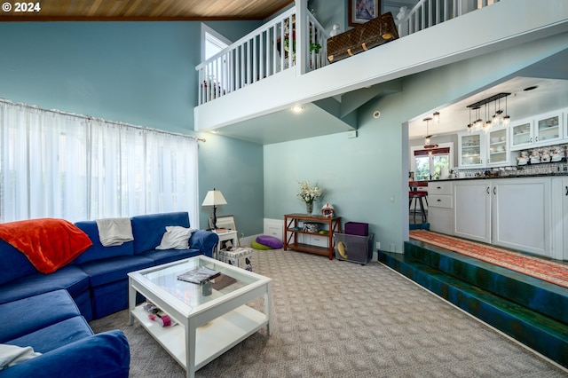 living room featuring wooden ceiling, high vaulted ceiling, a chandelier, and carpet flooring