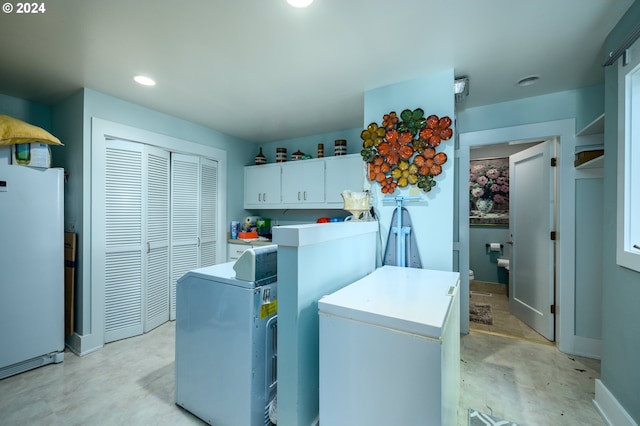 kitchen featuring white refrigerator, a center island, and white cabinets