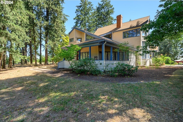 rear view of house featuring a porch