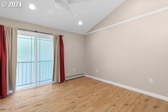 spare room featuring lofted ceiling, a baseboard radiator, light wood-type flooring, and ceiling fan