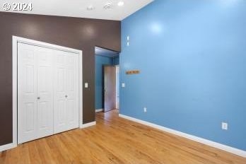 unfurnished bedroom with light hardwood / wood-style flooring and a closet