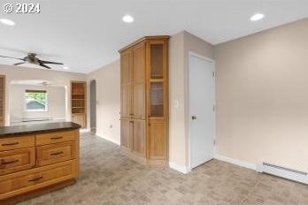 kitchen with light carpet, a baseboard heating unit, and ceiling fan