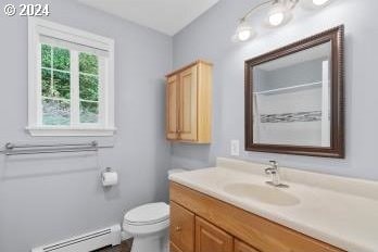 bathroom featuring vanity, toilet, and baseboard heating