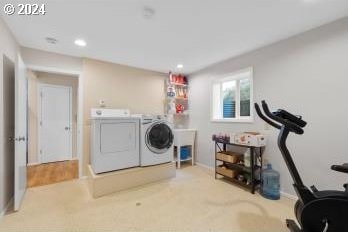 clothes washing area with carpet flooring and separate washer and dryer