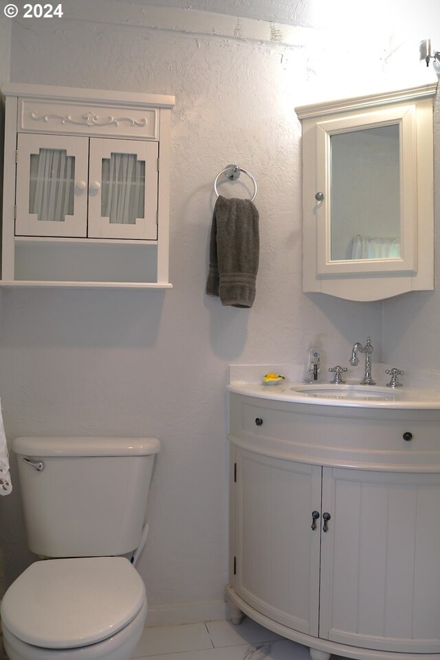 bathroom featuring tile patterned floors, vanity, and toilet