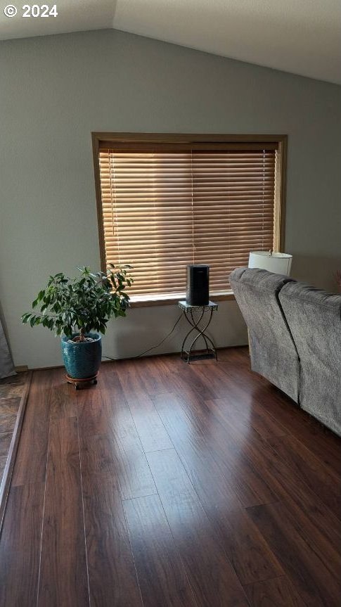 unfurnished bedroom with dark hardwood / wood-style flooring and vaulted ceiling