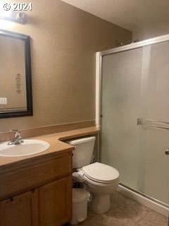 bathroom featuring walk in shower, vanity, and toilet