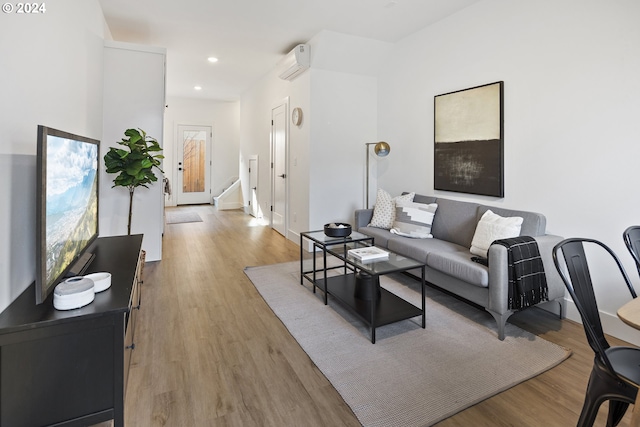 living room featuring light hardwood / wood-style floors and a wall mounted AC