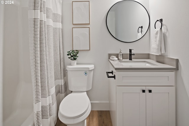 bathroom featuring a shower with curtain, vanity, hardwood / wood-style flooring, and toilet