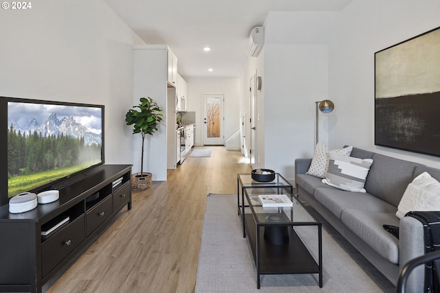 living room featuring an AC wall unit and light hardwood / wood-style flooring