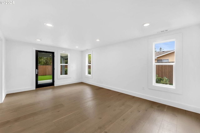 spare room featuring light hardwood / wood-style floors and plenty of natural light