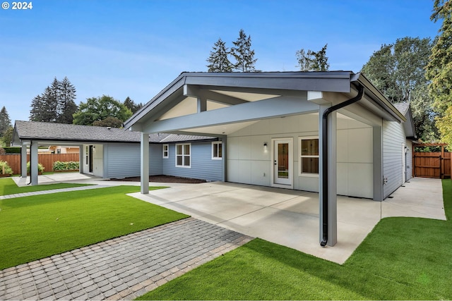 rear view of property featuring a lawn, french doors, and a patio area