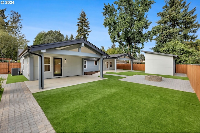 back of property with a patio, cooling unit, a yard, and a fire pit