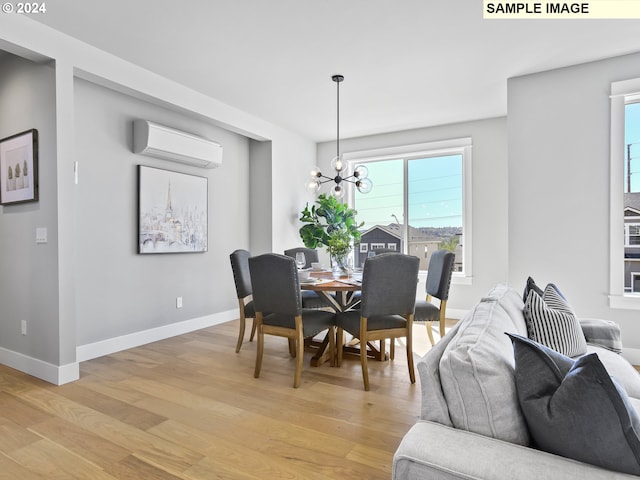 dining room featuring a wall mounted AC, an inviting chandelier, and light wood-type flooring