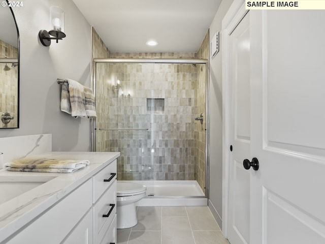 bathroom with vanity, walk in shower, toilet, and tile patterned floors