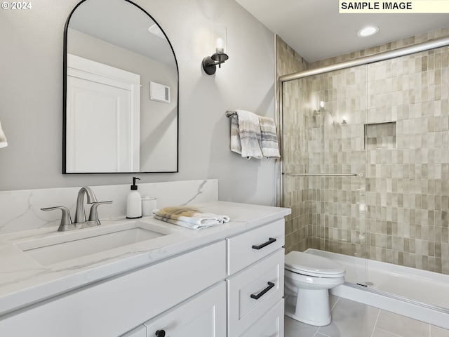 bathroom featuring toilet, an enclosed shower, vanity, and tile patterned floors